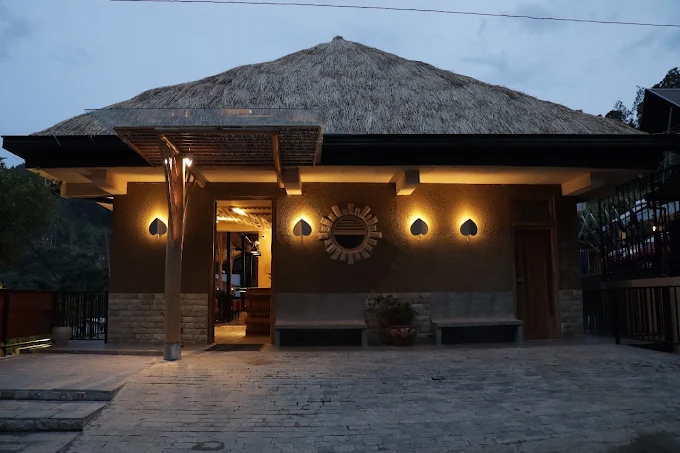 Thatched pavilion exterior of The Feel Luxury Boutique Hotel Ella lit at dusk